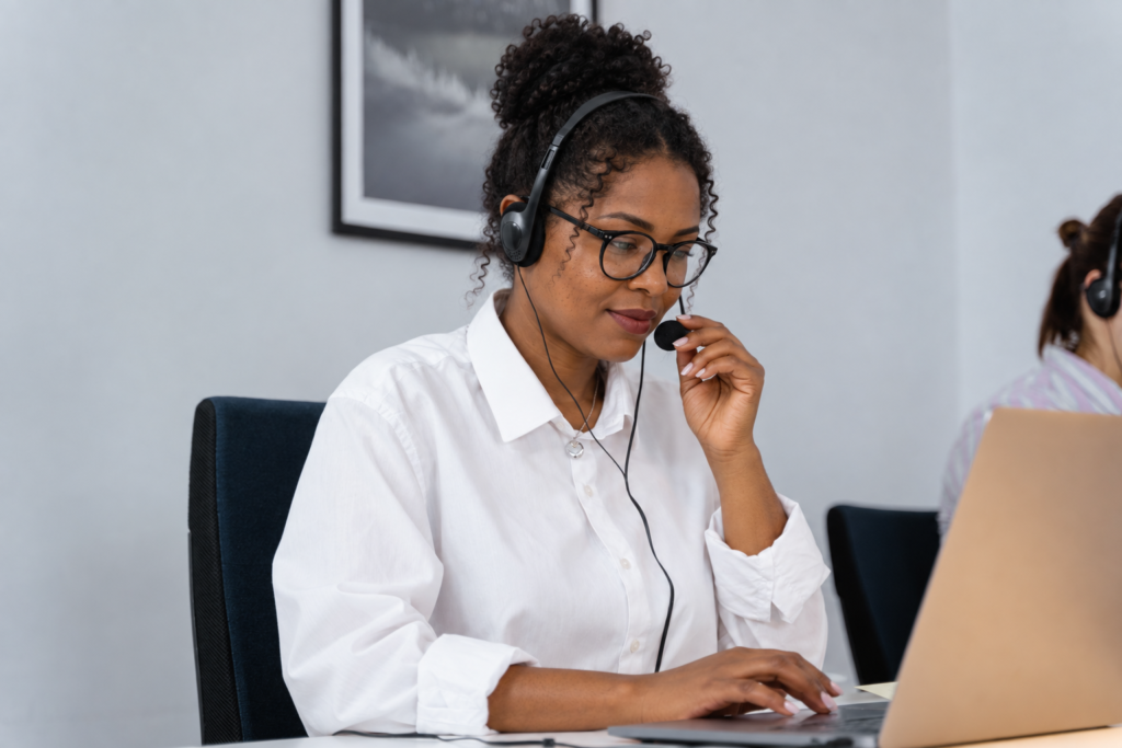 Cold caller wearing a headset while working at a laptop